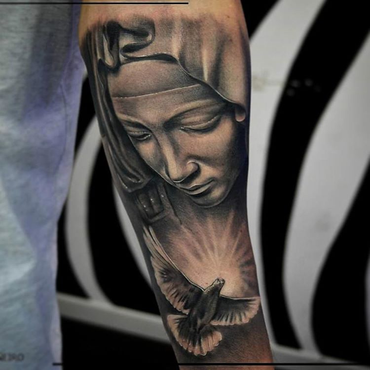 Black and grey Virgin Mary tattoo on the upper arm