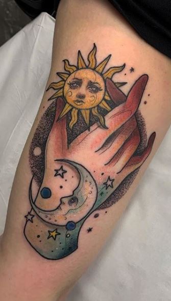 Individual matching hand holding sun and moon tattoo