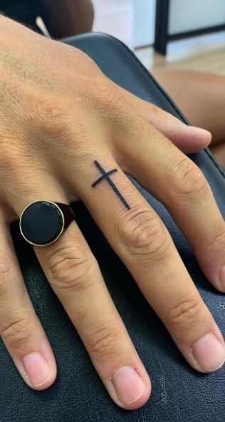cross on ring finger tattoo